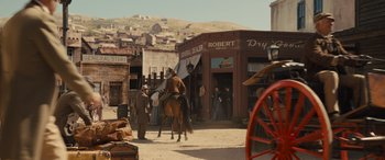Movie still from “Redeeming Love” (2022), directed by D.J. Caruso – A man riding a horse in a town square; Wide shot, Low angle