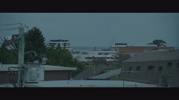 Movie still from “Relic” (2020), directed by Natalie Erika James – A view of a city from a distance; Extreme Wide shot, Low angle