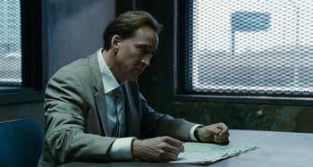 Movie still from “Bad Lieutenant: Port of Call New Orleans” (2009), directed by Werner Herzog – A man sitting at a table writing on a piece of paper; Close Up shot, Over the shoulder angle