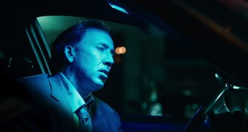 Movie still from “Bad Lieutenant: Port of Call New Orleans” (2009), directed by Werner Herzog – A man sitting in the back of a car at night; Close Up shot, Low angle