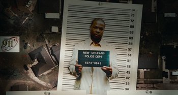 Movie still from “Bad Lieutenant: Port of Call New Orleans” (2009), directed by Werner Herzog – A mugshot of a man in a police station; Close Up shot, Overhead angle