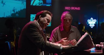 Movie still from “Bad Lieutenant: Port of Call New Orleans” (2009), directed by Werner Herzog – Two men are looking at a tablet in a bar; Medium shot, Over the shoulder angle