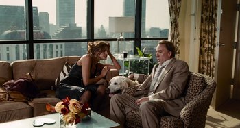 Movie still from “Bad Lieutenant: Port of Call New Orleans” (2009), directed by Werner Herzog – A man and a woman sitting on a couch with a dog; Medium shot, Over the shoulder angle