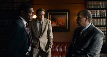 Movie still from “Bad Lieutenant: Port of Call New Orleans” (2009), directed by Werner Herzog – A group of men standing next to each other in a room; Medium shot, Over the shoulder angle