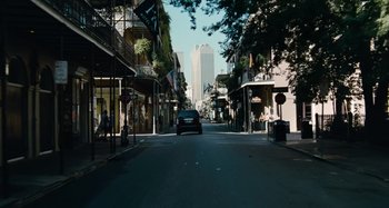 Movie still from “Bad Lieutenant: Port of Call New Orleans” (2009), directed by Werner Herzog – A car driving down a street with tall buildings in the background; Extreme Wide shot, Low angle