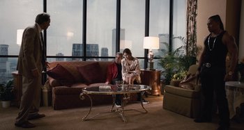 Movie still from “Bad Lieutenant: Port of Call New Orleans” (2009), directed by Werner Herzog – A man and a woman sitting on a couch in front of a window; Wide shot, High angle
