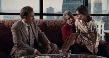 Movie still from “Bad Lieutenant: Port of Call New Orleans” (2009), directed by Werner Herzog – A group of people sitting on top of a red couch; Medium shot, Over the shoulder angle