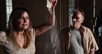 Movie still from “Bad Lieutenant: Port of Call New Orleans” (2009), directed by Werner Herzog – A woman holding a condom while standing next to an older man; Medium shot, Low angle