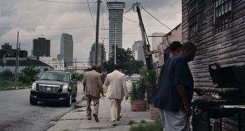 Movie still from “Bad Lieutenant: Port of Call New Orleans” (2009), directed by Werner Herzog – A group of men walking down a sidewalk; Extreme Wide shot, Low angle