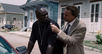 Movie still from “Bad Lieutenant: Port of Call New Orleans” (2009), directed by Werner Herzog – A man in a suit and a man in a black t - shirt; Medium shot, Over the shoulder angle