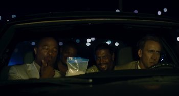Movie still from “Bad Lieutenant: Port of Call New Orleans” (2009), directed by Werner Herzog – A group of men sitting in the back of a car at night; Medium shot, High angle