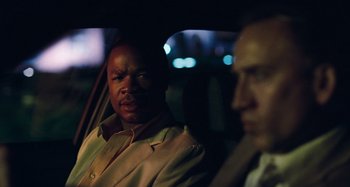 Movie still from “Bad Lieutenant: Port of Call New Orleans” (2009), directed by Werner Herzog – Two men sitting in the back of a car at night; Close Up shot, Over the shoulder angle
