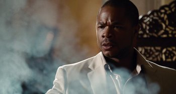 Movie still from “Bad Lieutenant: Port of Call New Orleans” (2009), directed by Werner Herzog – A man in a white suit is looking at the camera; Close Up shot, Over the shoulder angle