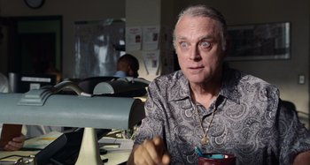 Movie still from “Bad Lieutenant: Port of Call New Orleans” (2009), directed by Werner Herzog – An older man sitting in front of a computer desk; Close Up shot, Low angle