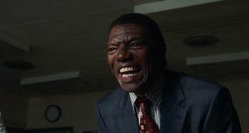 Movie still from “Bad Lieutenant: Port of Call New Orleans” (2009), directed by Werner Herzog – A man in a suit and tie with his mouth wide open; Close Up shot, Low angle