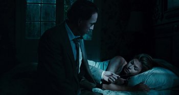 Movie still from “Bad Lieutenant: Port of Call New Orleans” (2009), directed by Werner Herzog – A man and a woman sitting in a dark room; Medium shot, Over the shoulder angle