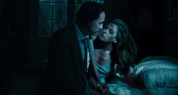 Movie still from “Bad Lieutenant: Port of Call New Orleans” (2009), directed by Werner Herzog – A man and a woman are kissing in a dark room; Medium shot, Low angle