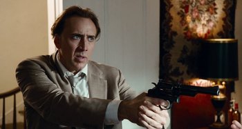 Movie still from “Bad Lieutenant: Port of Call New Orleans” (2009), directed by Werner Herzog – A man in a suit and tie holding a gun in his hand; Close Up shot, Over the shoulder angle