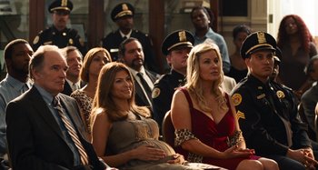 Movie still from “Bad Lieutenant: Port of Call New Orleans” (2009), directed by Werner Herzog – A group of people sitting next to each other in a room; Medium shot, Over the shoulder angle