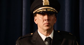 Movie still from “Bad Lieutenant: Port of Call New Orleans” (2009), directed by Werner Herzog – A man in a police officer's uniform and hat; Close Up shot, Over the shoulder angle