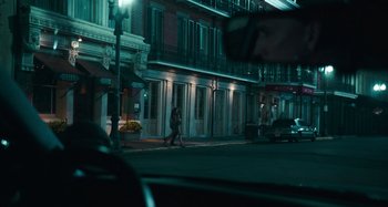 Movie still from “Bad Lieutenant: Port of Call New Orleans” (2009), directed by Werner Herzog – A person walking down a street at night; Wide shot, Over the shoulder angle