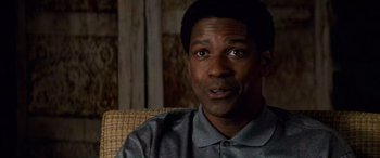 Movie still from “Remember the Titans” (2000), directed by Boaz Yakin – A man sitting on a couch looking at the camera; Close Up shot, Over the shoulder angle