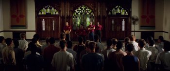 Movie still from “Remember the Titans” (2000), directed by Boaz Yakin – A group of men standing in front of an audience; Wide shot, High angle