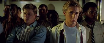 Movie still from “Remember the Titans” (2000), directed by Boaz Yakin – A group of men standing next to each other in a room; Close Up shot, Low angle