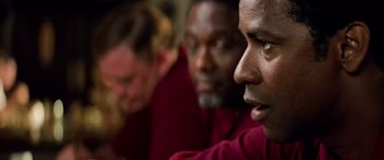 Movie still from “Remember the Titans” (2000), directed by Boaz Yakin – A group of men sitting next to each other in a room; Close Up shot, Over the shoulder angle