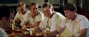 Movie still from “Remember the Titans” (2000), directed by Boaz Yakin – A couple of men sitting next to each other at a table; Medium shot, Over the shoulder angle