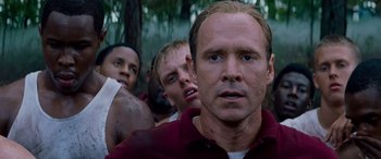 Movie still from “Remember the Titans” (2000), directed by Boaz Yakin – A group of men standing next to each other in the woods; Close Up shot, Low angle