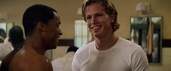 Movie still from “Remember the Titans” (2000), directed by Boaz Yakin – A man with blonde hair and a white shirt is talking to another man; Close Up shot, Over the shoulder angle