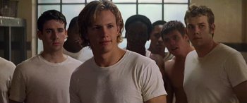 Movie still from “Remember the Titans” (2000), directed by Boaz Yakin – A group of men standing next to each other in front of a window; Close Up shot, Over the shoulder angle