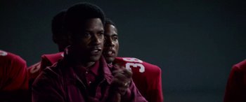 Movie still from “Remember the Titans” (2000), directed by Boaz Yakin – Two young black men standing next to each other in a dark room; Close Up shot, Over the shoulder angle