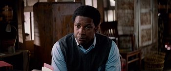 Movie still from “Remember the Titans” (2000), directed by Boaz Yakin – A man sitting in front of a wooden table; Close Up shot, Over the shoulder angle