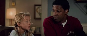 Movie still from “Remember the Titans” (2000), directed by Boaz Yakin – A man and a little girl in a living room; Close Up shot, Over the shoulder angle