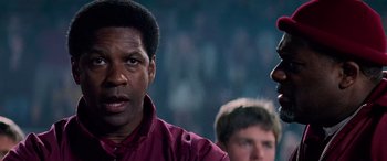 Movie still from “Remember the Titans” (2000), directed by Boaz Yakin – A person with a crowd in the background; Close Up shot, Over the shoulder angle