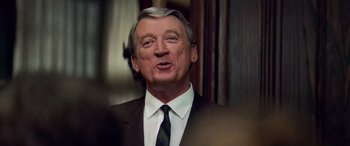 Movie still from “Remember the Titans” (2000), directed by Boaz Yakin – An older man wearing a suit and tie; Close Up shot, Over the shoulder angle