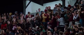 A group of people sitting in a crowd of people