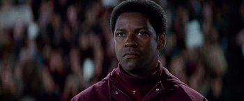 Movie still from “Remember the Titans” (2000), directed by Boaz Yakin – A man in a maroon jacket looking to his left; Close Up shot, Low angle