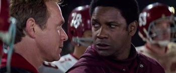 Movie still from “Remember the Titans” (2000), directed by Boaz Yakin – Two football players talking to each other in a huddle; Close Up shot, Over the shoulder angle