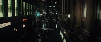 Movie still from “Reminiscence” (2021), directed by Lisa Joy – A city street at night lit by street lights; Extreme Wide shot, High angle