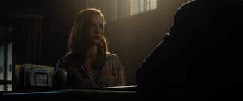 Movie still from “Reminiscence” (2021), directed by Lisa Joy – A woman sitting in front of a piano in a darkened room; Medium shot, Over the shoulder angle