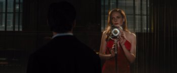Movie still from “Reminiscence” (2021), directed by Lisa Joy – A woman in a red dress taking a picture in a mirror; Medium shot, Over the shoulder angle