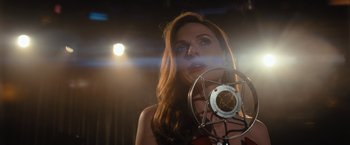 Movie still from “Reminiscence” (2021), directed by Lisa Joy – A beautiful woman standing in front of a microphone; Close Up shot, Low angle