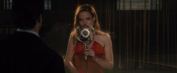 Movie still from “Reminiscence” (2021), directed by Lisa Joy – A woman in a red dress is holding a microphone; Medium shot, Over the shoulder angle