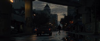 Movie still from “Reminiscence” (2021), directed by Lisa Joy – A man walking down the street in the rain; Extreme Wide shot, Low angle