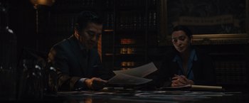 Movie still from “Reminiscence” (2021), directed by Lisa Joy – A man and a woman sitting at a table looking at papers; Medium shot, Over the shoulder angle