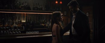 Movie still from “Reminiscence” (2021), directed by Lisa Joy – A man and a woman standing next to each other in front of a bar; Medium shot, Over the shoulder angle