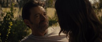 Movie still from “Reminiscence” (2021), directed by Lisa Joy – A person sitting on a couch near a tree; Close Up shot, Over the shoulder angle